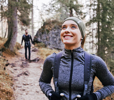 a woman and a man hiking in a forest