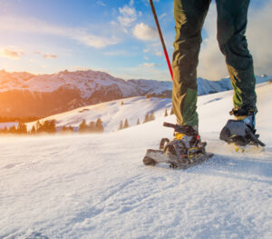 person walking in snow with snow shoes