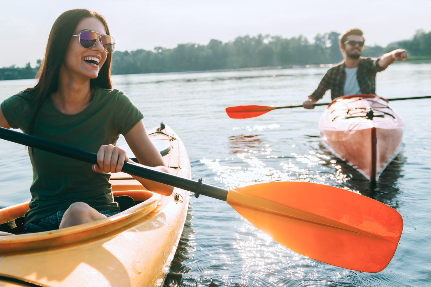 Two people kayaking on a lake near Newpark Resort in Park City, Utah